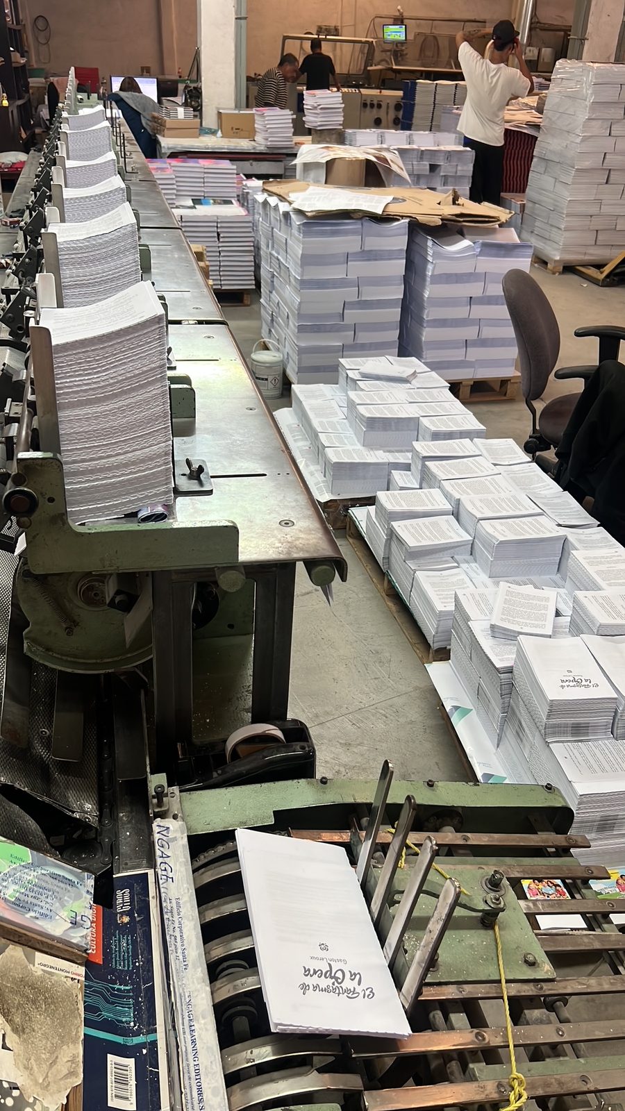 Línea de producción con pilas de pliegos